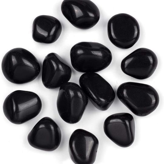 Close-up of Black Obsidian tumbled stones available for sale, emphasizing their protective energy.