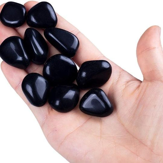 Natural Black Obsidian tumbled stones showcasing their glossy finish and powerful healing properties.