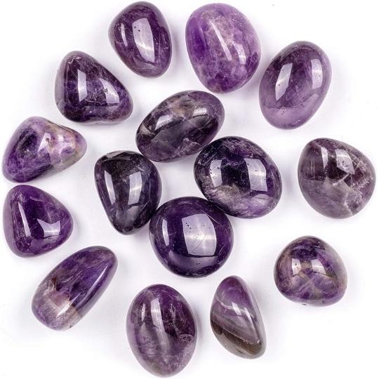 Close-up of an Amethyst worry stone and tumbled stones, emphasizing their calming and spiritual benefits.