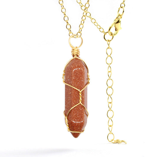 Close-up of a Goldstone Necklace featuring a shimmering gemstone wrapped in handcrafted gold wire with a stainless steel chain.