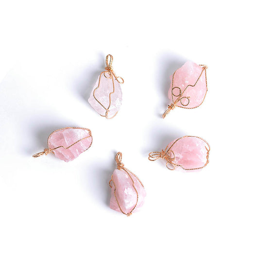 Close-up of a Rose Quartz Necklace featuring a soft pink gemstone wrapped in artisan gold wire with a stainless steel chain.