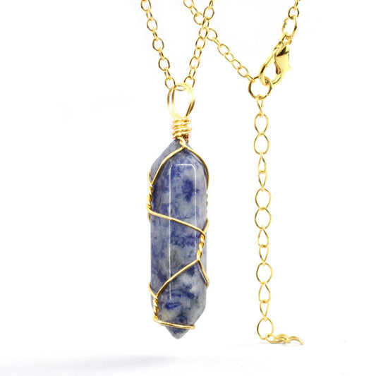 Close-up of a Sodalite Necklace featuring a deep blue gemstone wrapped in handcrafted gold wire with a stainless steel chain.